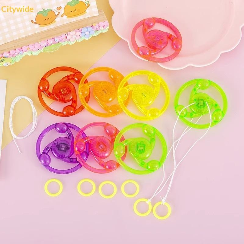 Colorful plastic toys with strings on a pink background