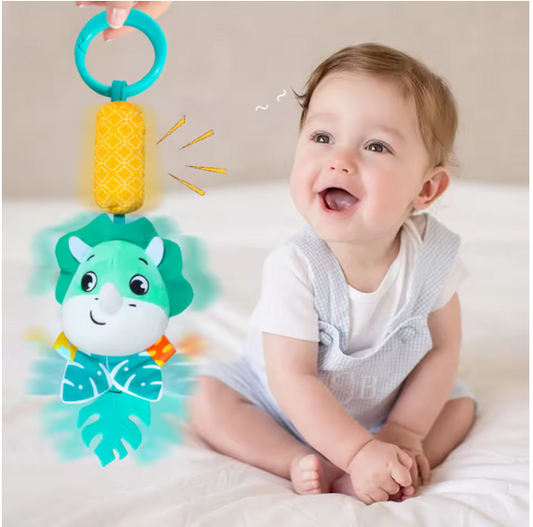 Happy Baby Playing with a Musical Dinosaur Rattle Toy
