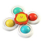 A colorful baby toy fidget spinner with a lion face in the center and four circular buttons in yellow, teal, red, and light blue, set against a plain white background.