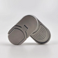 A metallic gray fidget spinner with a smooth oval body, featuring a split design with one half showing a smooth surface and the other half displaying concentric arches.