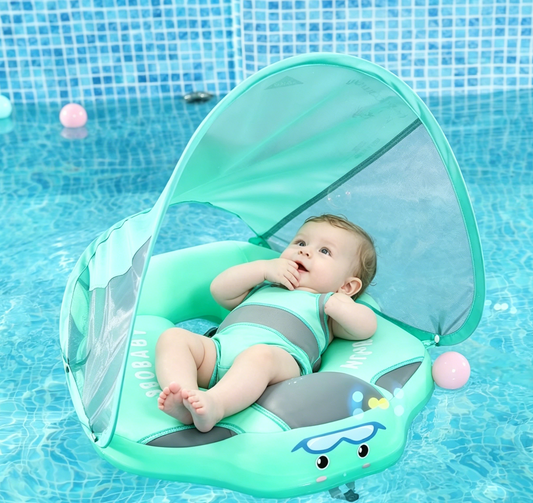 A baby wearing a one-piece swimsuit sits in a mint green inflatable baby pool float with a pop-up canopy, floating in a blue swimming pool.