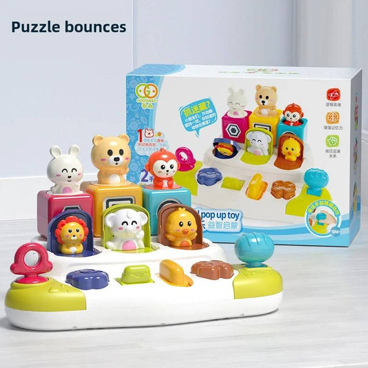 A colorful children's pop-up toy puzzle set with multiple cartoon animal characters and interactive buttons, shown with its retail box on a light indoor surface. The box reads 'Puzzle bounces' and 'pop up toy'.