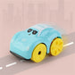 A light blue toy car with a cartoon face and yellow wheels, shown on a stylized road with a soft pink cityscape background.